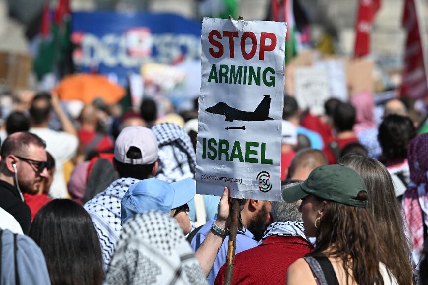 A protestor with a sign that reads 'Stop arming Israel' at a Berlin protest in June