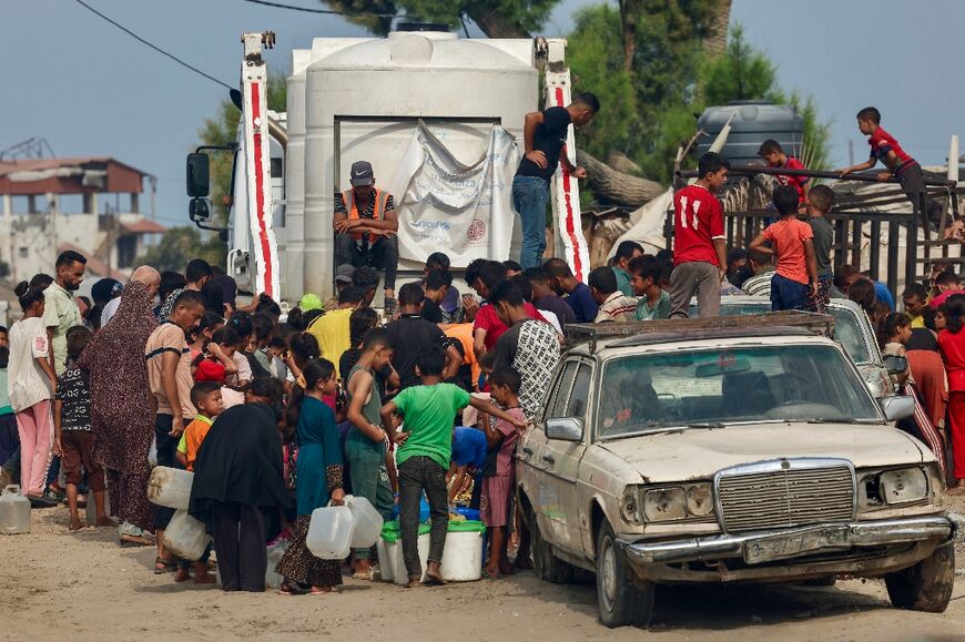 Palestinians in southern Gaza queue at a water distribution point amid severe shortages more than 22 months into the war
