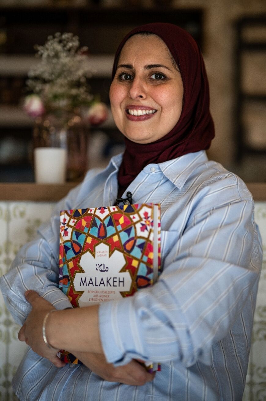 Success story: Syrian  Malakeh Jazmati in her Berlin restaurant with her cookbook