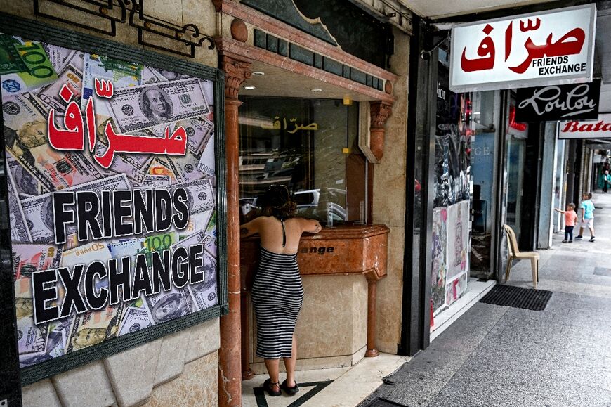 A woman waits at a currency exchange office in Beirut in this file picture taken on June 20, 2024