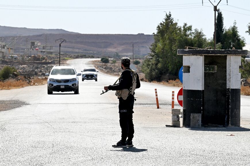 A member of Syria's security forces stands guard at a checkpoint near the city of Quneitra