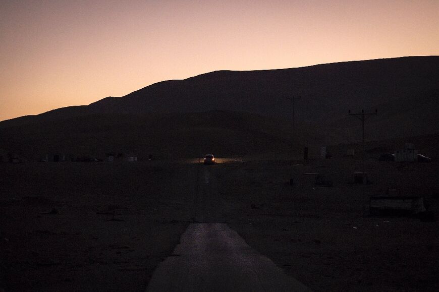 A vehicle enters Ras Ein al-Auja at sunset