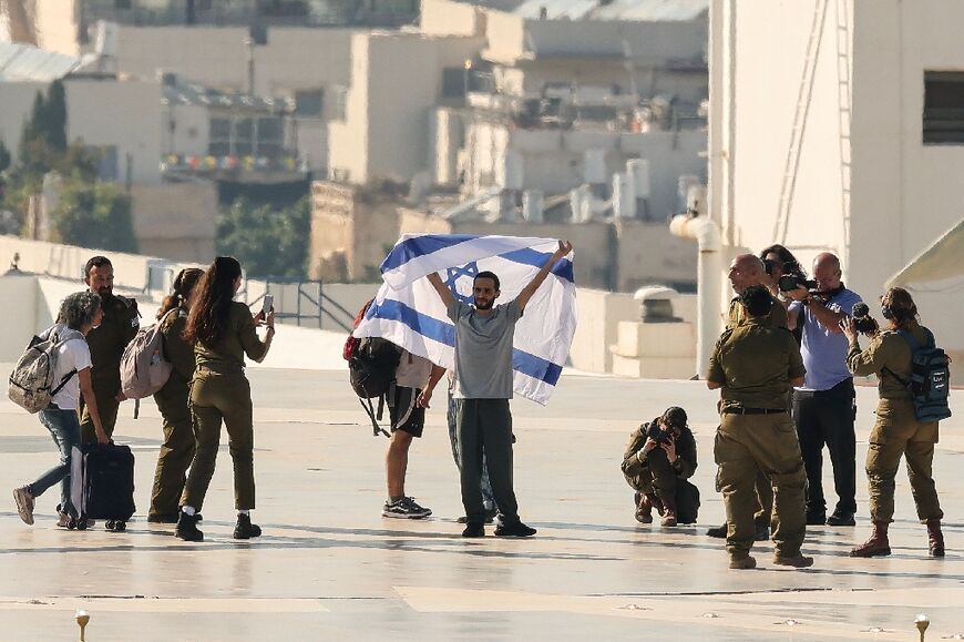 Surving Israeli hostages like Nimrod Cohen (centre with flag) have now returned to Israel but the remains of 24 who died in Gaza are still missing