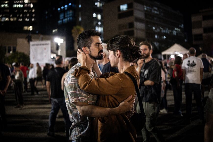 A couple embraces at Hostage Square in Tel Aviv on October 9, 2025, during a gathering following the announcement of the new Gaza ceasefire deal