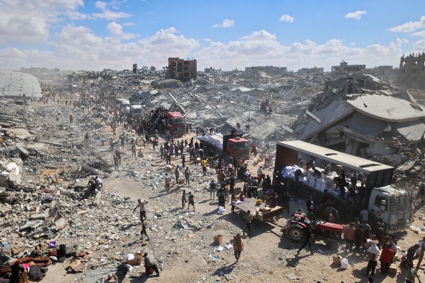 Conditions remain dire in Gaza, were Palestinians are seen gathering at aid trucks as a ceasefire between Israel and Palestinian factions holds in the besieged territory