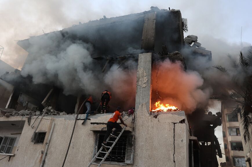 Civil defence personnel searched a burning house in Gaza City