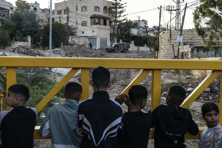 Palestinians waited behind a barrier to retreive their belongings during an Israeli forces raid on the outskirts of the Jenin refugee camp