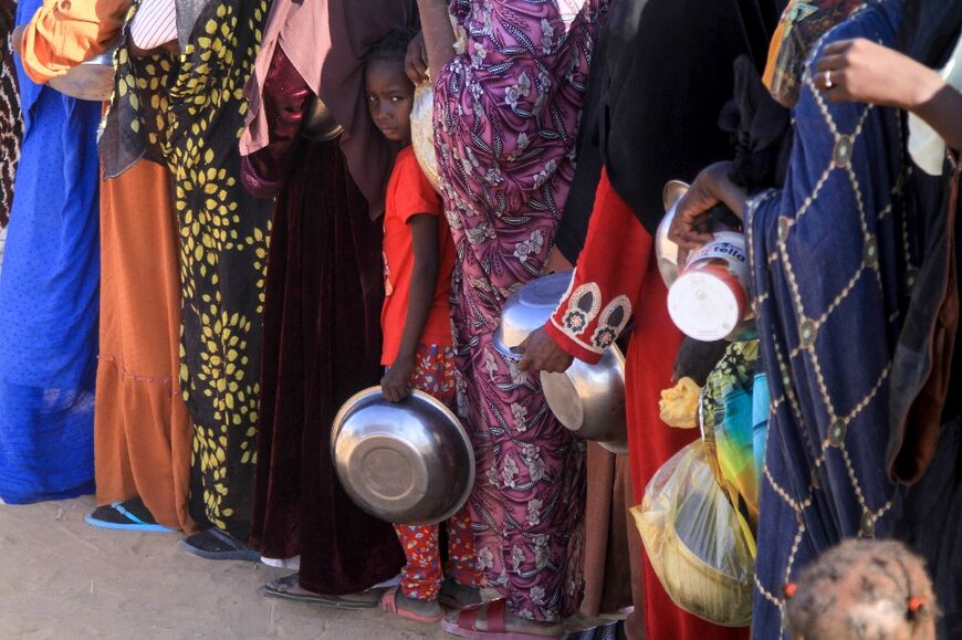 A Sudanese girl who fled El-Fasher lines up with others to receive a free meal at the Al-Dabbah camp