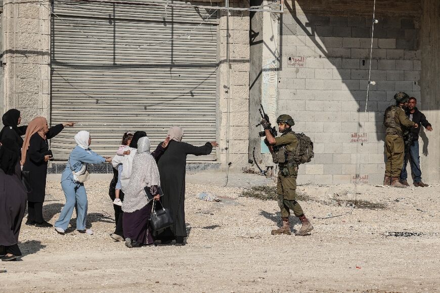 Palestinian women react as Israeli soldiers detain a resident of the Nur Shams refugee camp