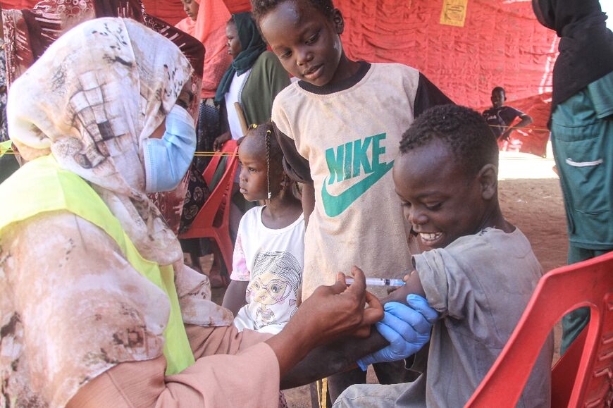 A child is vaccinated against diphtheria at the Al-Dabbah camp for displaced people in Sudan