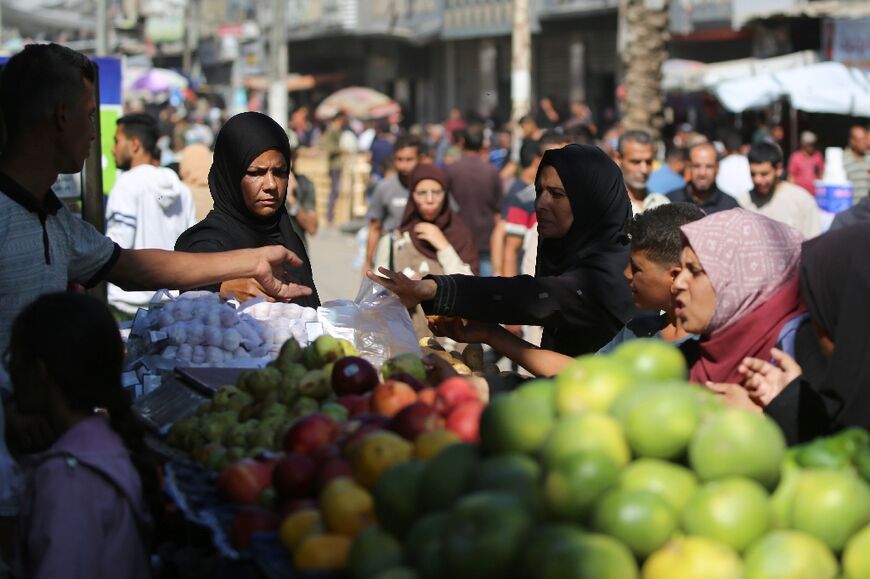 Palestinians shop for fruit and vegetables at a makeshift market in Nuseirat