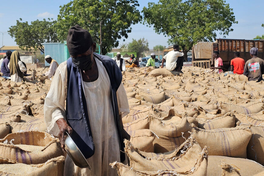 Sudanese farmers inspect sesame crops from sacks during the current harvest season at the Gedaref crop market, the largest crop market in the country, in eastern Sudan on November 12, 2025. Two UN food agencies warned November 11 that millions more people around the globe could face famine, with funding shortfalls worsening already dire conditions. The joint report from the Food and Agriculture Organization and the World Food Programme said conflict and violence were driving acute food insecurity in the maj