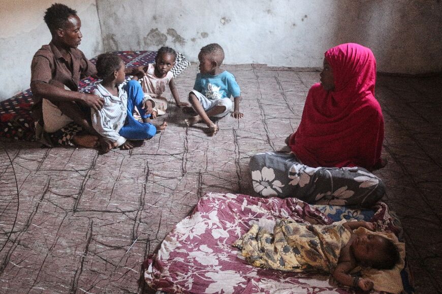 Somali refugee Abdallah Omar (L) sits with his wife and his children at a UN Refugee Agency (UNHCR) facility, as they wait for news of their repatriation from Yemen