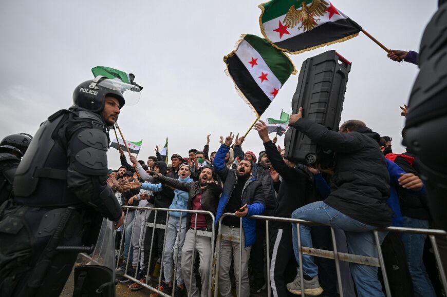 Syrians celebrate the anniversary of the toppling of longtime ruler Bashar al-Assad in Damascus