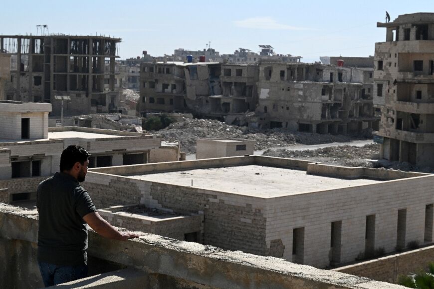Civil society leader Hussam Lahham looks out from the destroyed National Hospital onto the ruins of Daraya