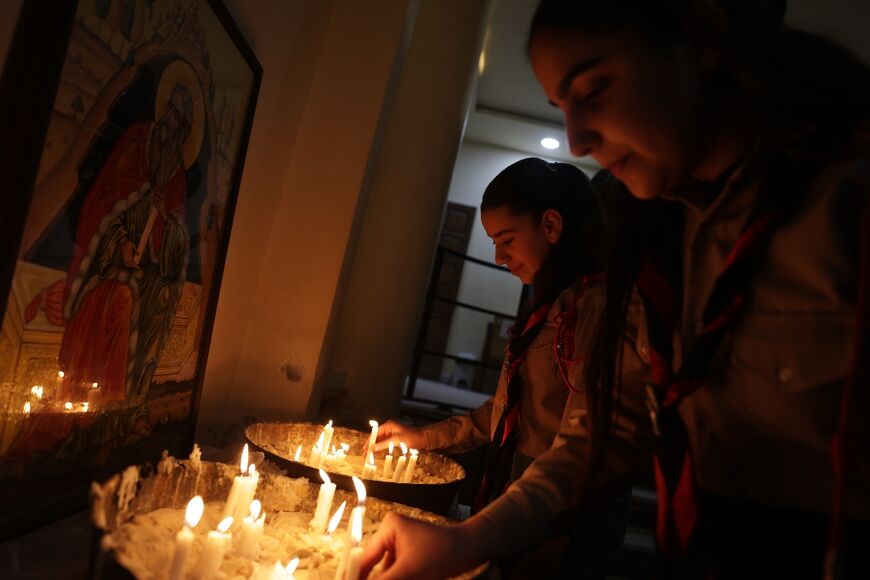 Hanaa Masoud lights candles for her husband Boutros Bashara, who was among those killed in the attack in June