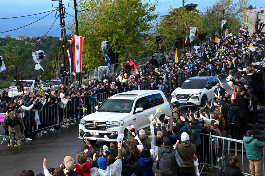 People wave as Pope Leo XIV's motorcade leaves the tomb of Saint Charbel Makhlouf in Annaya, north of Beirut, on December 1, 2025. Pope Leo XIV is set to urge peace and unity on his second day in Lebanon on December 1, 2025, bringing a message of hope to young people whose faith in their crisis-hit country has dwindled. (Photo by JOSEPH EID / AFP via Getty Images)