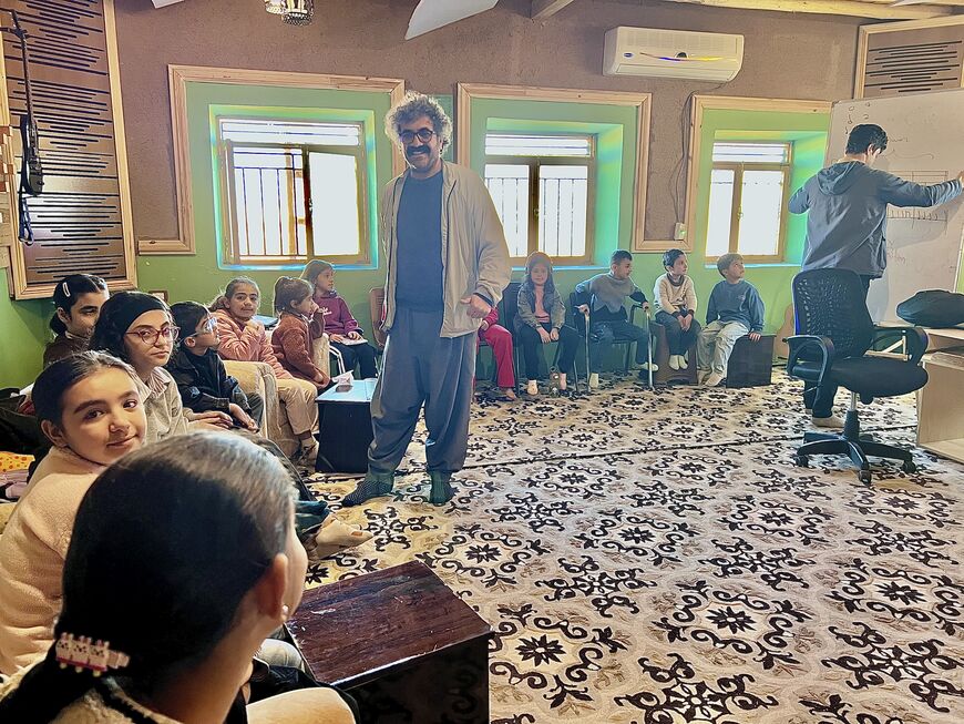 Filmmaker Sero Hindi teaches music to children at the Hunergeha Welat arts academy in Qamishli, Syria. Amberin Zaman. November 22, 2025