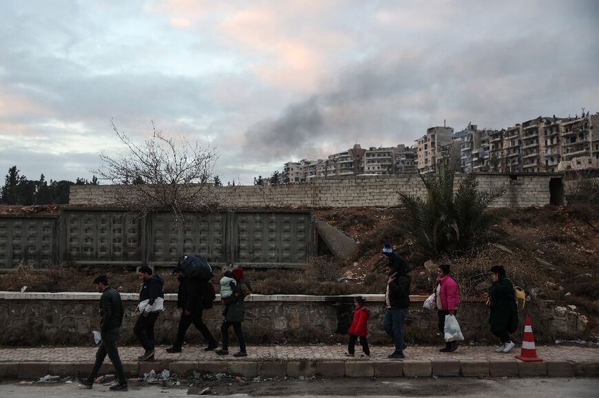 Residents carrying their belongings leave Aleppo's Kurdish-majority Sheikh Maqsud neighbourhood after days of deadly clashes 