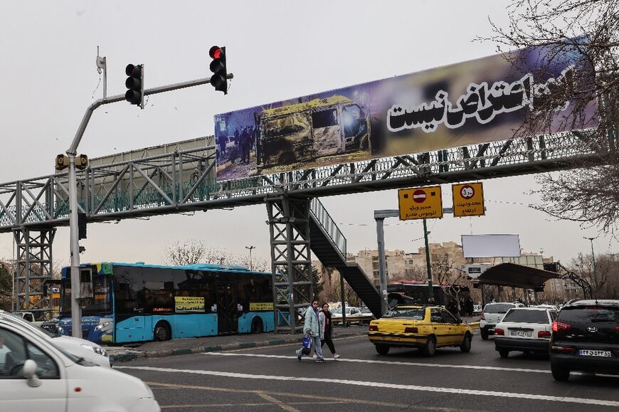 Cars drive under a banner that reads "This is not a protest" in Tehran 