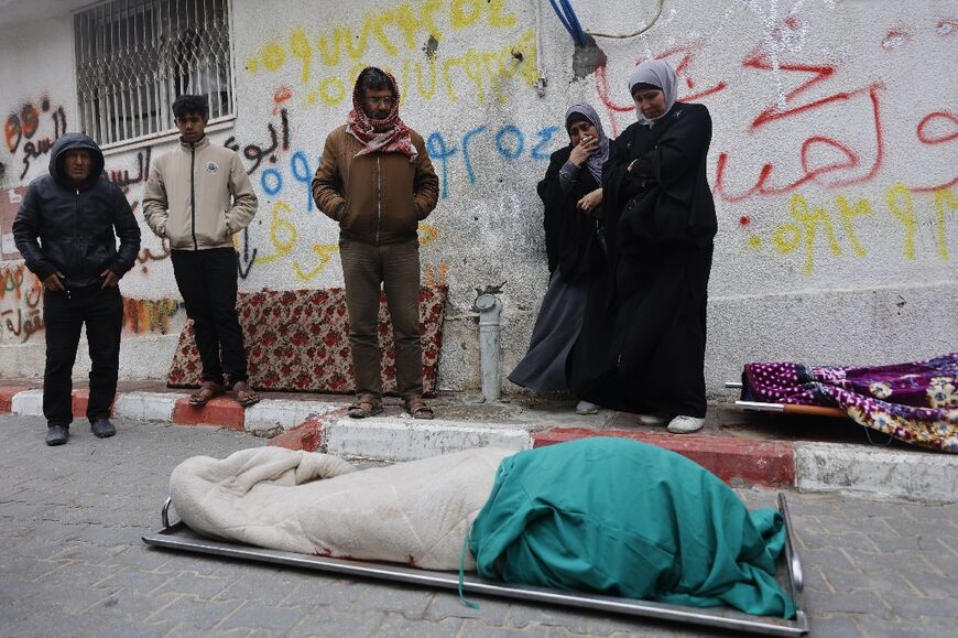 Palestinians mourn over a body