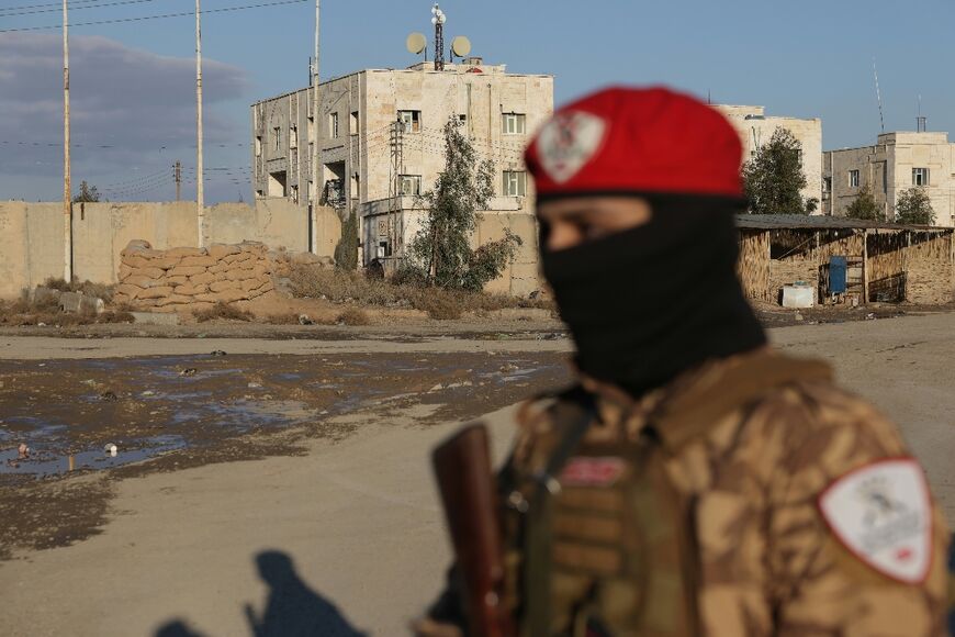 A Syrian government soldier stands guard outside the Al-Aktan prison that holds IS detainees in the city of Raqa