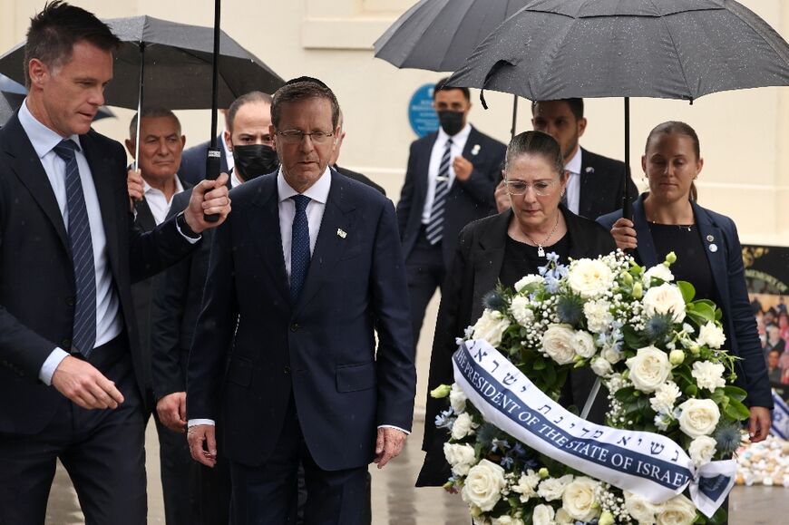 Israelli President Isaac Herzog (C) and his wife Michal (2nd R) are escorted by New South Wales Premier Chris Minns (L) as they lay a wreath for the victims of the December 14, 2025 gun attack at the Bondi Pavilion, in Sydney on February 9, 2026