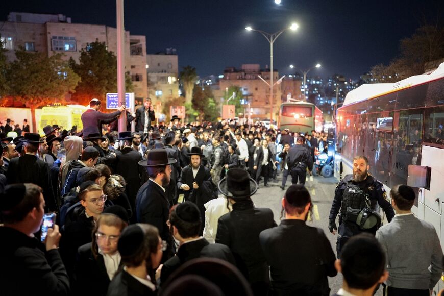 People and police officers gather around a bus following a deadly collision after the bus was surrounded by protesters in January