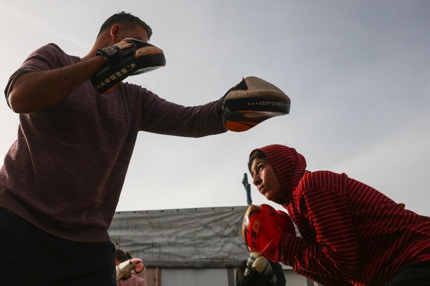 L'entraîneur de boxe Osama Ayoub et une de ses élèves lors d'un entraînement à Khan Younès, dans le sud de la bande de Gaza, le 9 février 2026