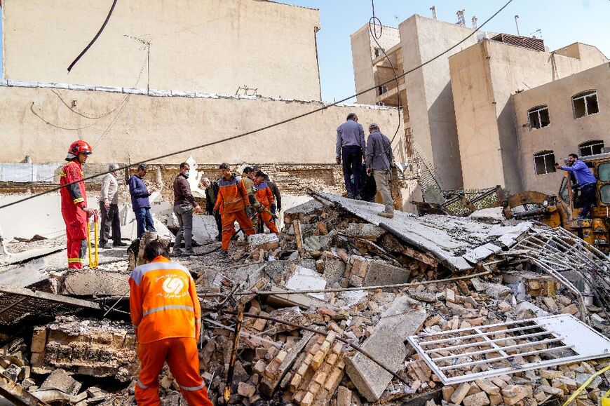 In this picture obtained from Iran's ISNA news agency, rescuers search through the rubble of a collapsed building at the site of a strike in Tehran 