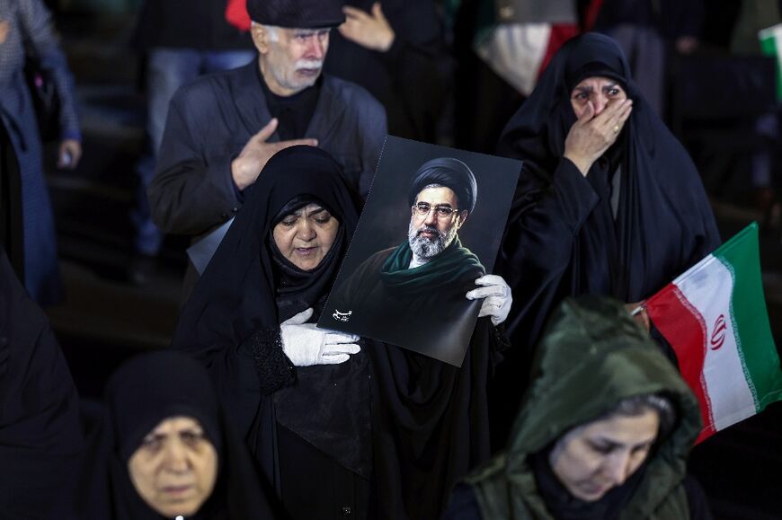 People held portraits of Iran's supreme leader Mojtaba Khamenei at a march to support the armed forces in Tehran on Thursday