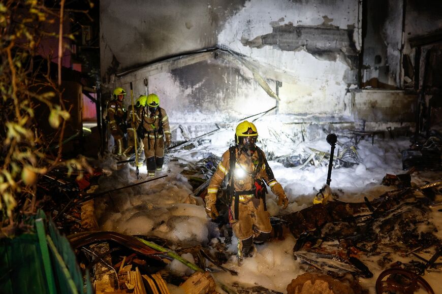 Firefighters work at the site of a strike in the northern Israeli city of Nahariya 