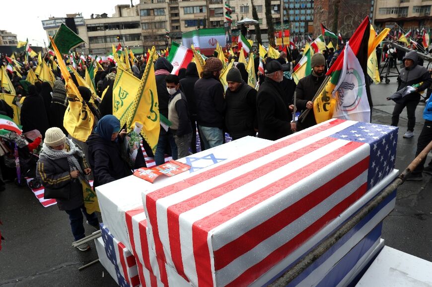 The pro-government demonstrators in Tehran piled symbolic coffins in the colours of the US and Israeli flags on each other