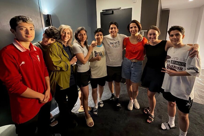 An undated photo released by Australia's Department of Home Affairs on March 11, 2026 shows two more members of the Iranian women's football team to claim asylum in Australia, player Mohaddeseh Zolfi (L) and support member Zahra Soltan Meshkeh Kar (3rd L), posing with their five other teammates who had earlier claimed asylum Fatemeh Pasandideh (2nd L), Atefeh Ramezanizadeh (4th L), Mona Hamoudi (C), Zahra Ghanbari (4th R), and Zahra Sarbali (R), along with two other local officials (2nd and 3rd R) in Sydney
