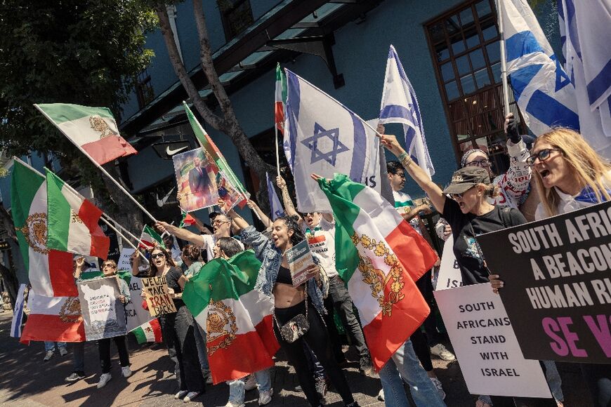 Supporters of Israel and Iranian pro-democracy activists chant slogans and hold flags in Cape Town