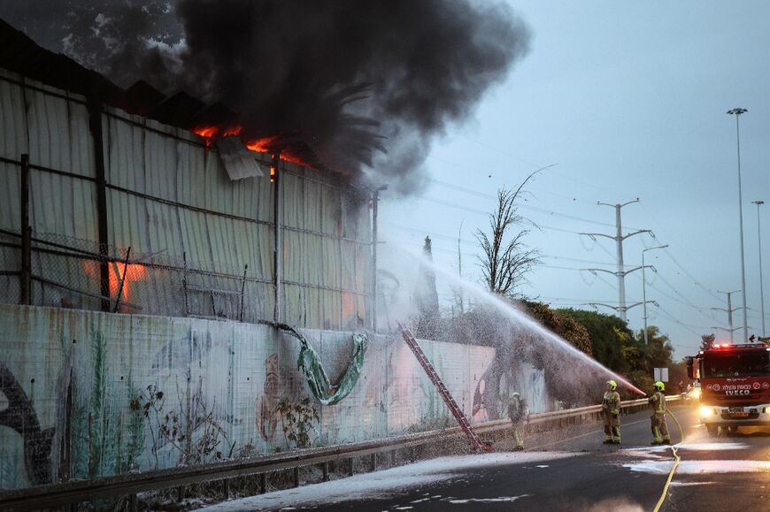 Firefighters at the site of a strike on the outskirts of Tel Aviv on Friday