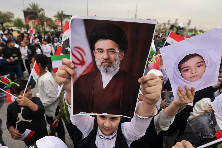TOPSHOT - A schoolgirl holds up a poster of Iran's new supreme leader Mojtaba Khamenei during an anti-US and Israel demonstration in Baghdad on March 12, 2026. Air strikes killed at least nine Iran-backed fighters in Iraq on March 12 near the Iraqi-Syrian border, two senior security officials told AFP. The Middle East war, which was triggered on February 28 by American-Israeli attacks on Iran, is hampering the global economy's supply of oil and weakening production capacity. (Photo by AHMAD AL-RUBAYE / AFP 