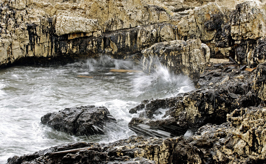 Waves splash on rocks still covered with black layers of oil at the coast of Amshit in northern Lebanon, 01 August 2007. Around a third of a massive oil slick caused by Israeli bombing of a Lebanese power plant remains in the Mediterranean a year on from war. Lebanon's coast was polluted by some 15,000 tonnes of fuel oil after the Israeli military bombed Lebanon's southern Jiyeh power station in mid-July 2006 during its 34-day offensive against the Shiite militia Hezbollah. Nearly three quarters of the Leba