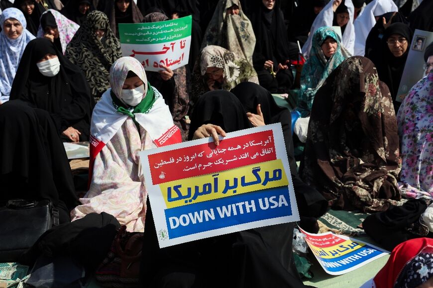 A woman holds an anti-US placard during Friday noon prayers in Tehran
