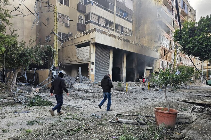 Firefighters inspect the site of an overnight Israeli airstrike on the Haret Hreik neighbourhood in Beirut's southern suburbs