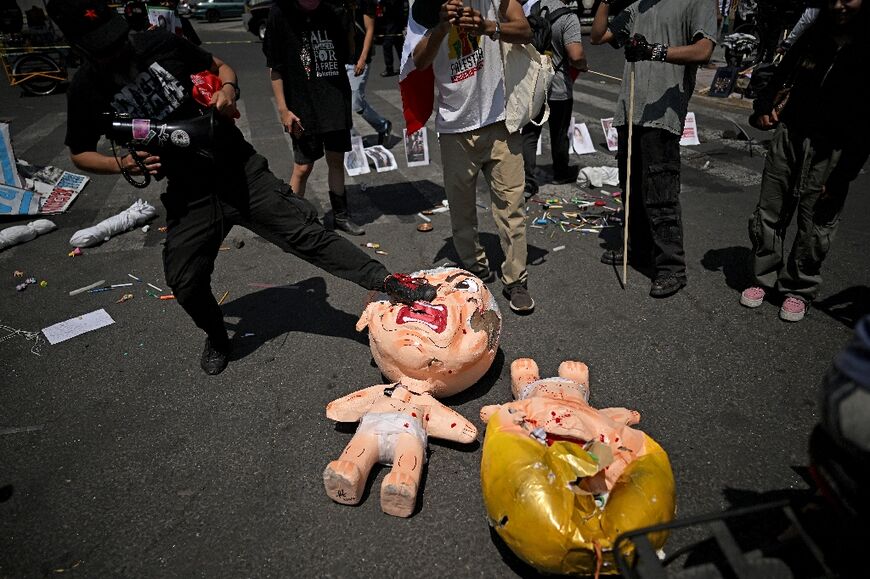 A protesters kicks a pinata depicting Israel's Prime Minister Benjamin Netanyahu in Mexico City
