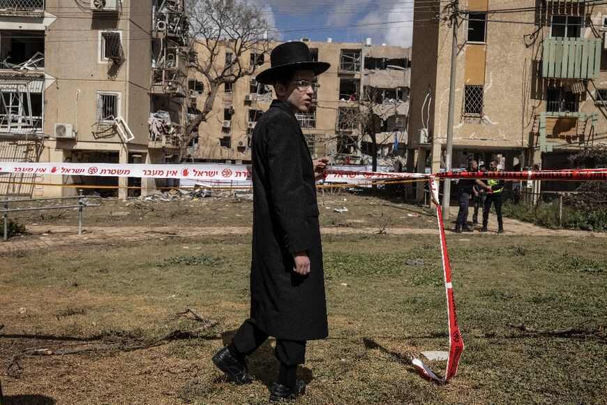 An Israeli Orthodox Jew inspects the site of an Iranian missile strike in Arad on March 22
