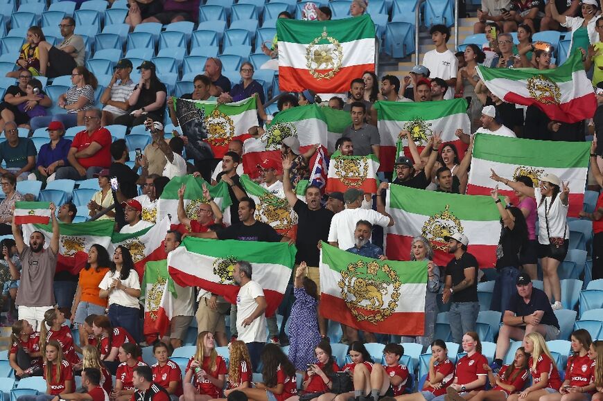 Iranian supporters wave flags from the late shah's era during the AFC Women's Asian Cup match against South Korea on the Gold Coast