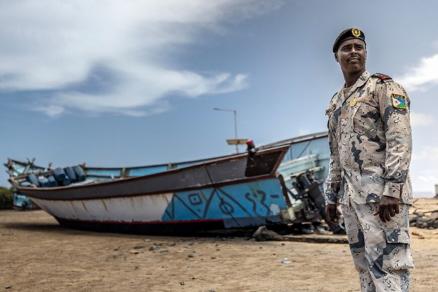 Djibouti coastguard commander Ismail Hassan Dirieh with one of the boats seized from smugglers 