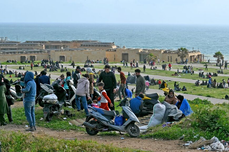 People who fled Beirut's southern suburbs after the latest Israeli bombing warning take refuge by a beach