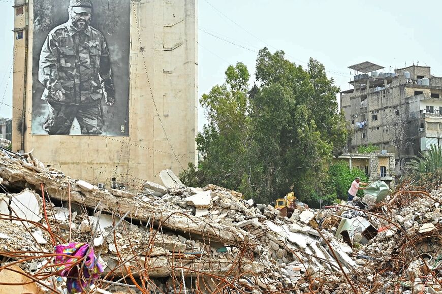A resident inspects the rubble of destroyed buildings on his return to the southern Lebanese city of Nabatieh
