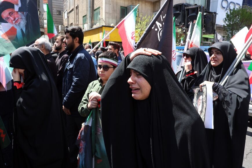 Iranians react during a rally to commemorate the death of the country's slain supreme leader Ayatollah Ali Khamenei in Tehran