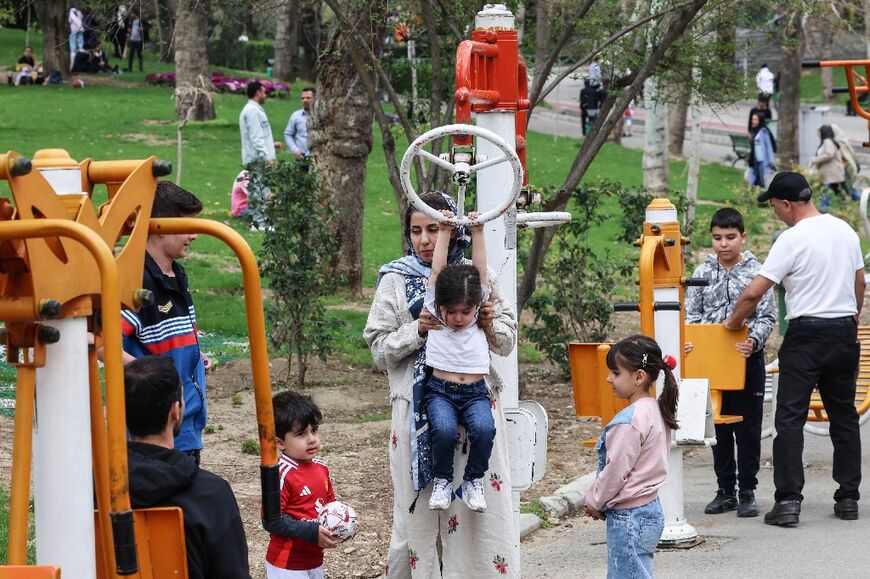 Children play on workout equipment at Tehran's Melat park during "Sizdeh Bedar" (Nature Day), the 13th day after the Nowruz Persian New Year