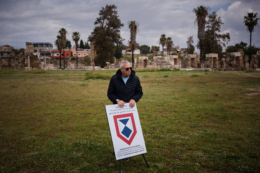 Nader Saqlawi, director of archaeological excavations in sothern Lebanon, places an Enhanced Protection Emblem, a special symbol used under international humanitarian law to protect critical sites during armed conflict, at the archaeological site of the Roman hippodrome in the southern Lebanese city of Tyre, on March 23, 2026. At the achaeological site of Al-Bass, in Lebanon's Tyre, there is no military defence, only a small sign bearing a blue and white emblem: the bulwark meant to protect the ancient ruin