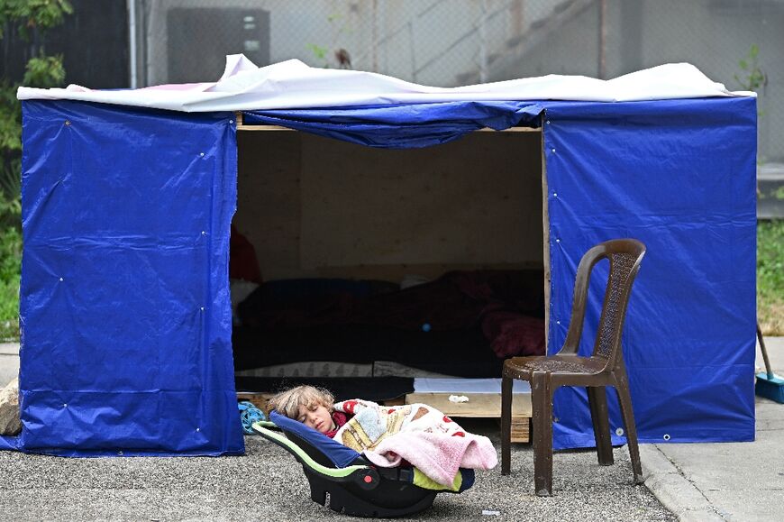 A displaced toddler sleeps at an unofficial camp in Beirut